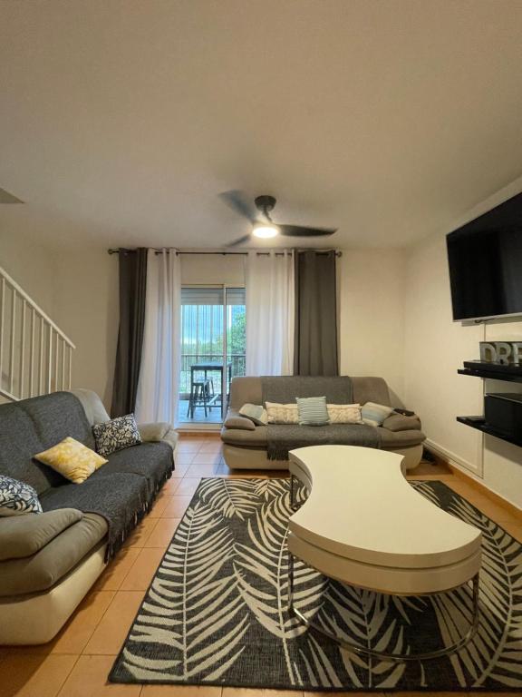 a living room with a couch and a table at CASA COLIVING avec chambre salle de bain individuelles privatives in Saint-Pierre