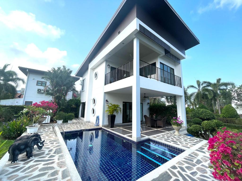 una casa con piscina frente a ella en Seabreeze Villa, en Rayong