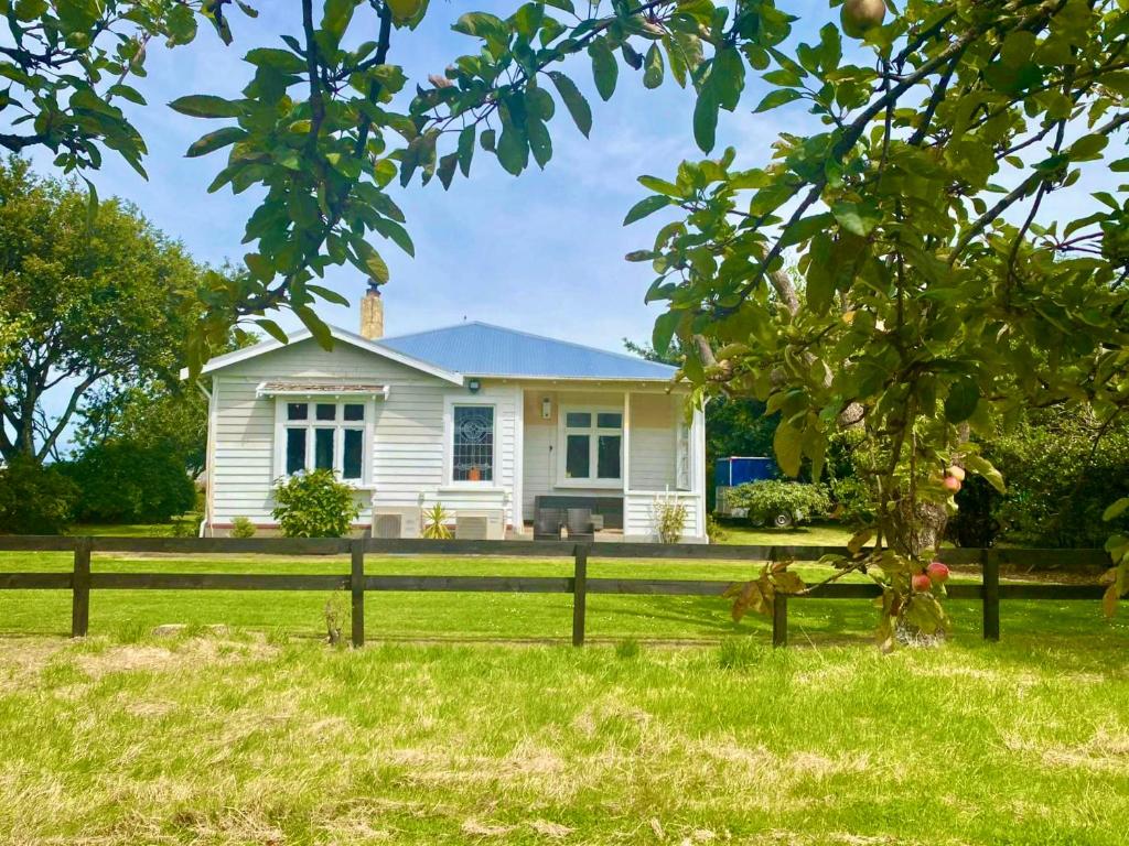 una casa blanca con una valla delante en Big Fully Equipped 3BRM Quiet Farm House Near Beach & 12 min to Town en Riverton