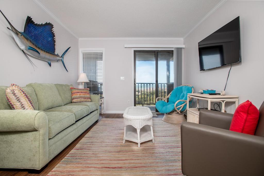 a living room with a couch and a tv at Southwinds G16 condo in Atlantic Beach