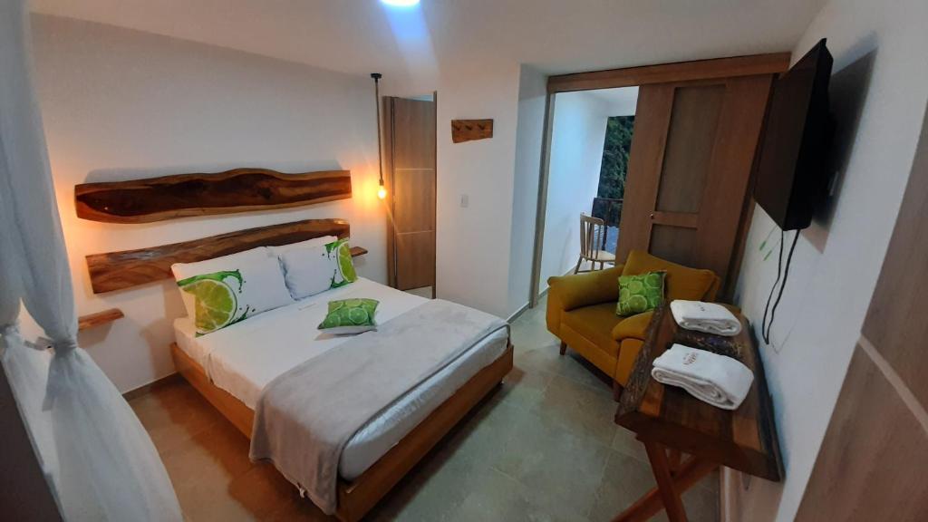 a small bedroom with a bed and a chair at AZAHARES HOTEL Y CAFÉ in Manizales