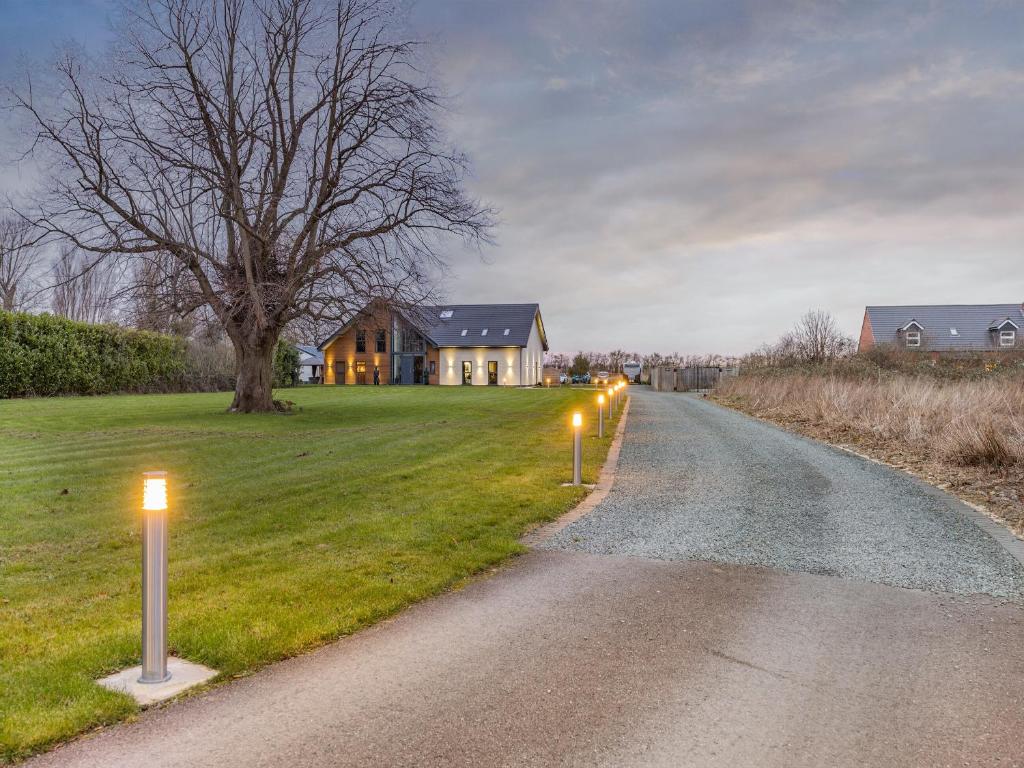 uma casa com luzes ao lado de uma estrada em The Paddocks Retreat em North Thoresby