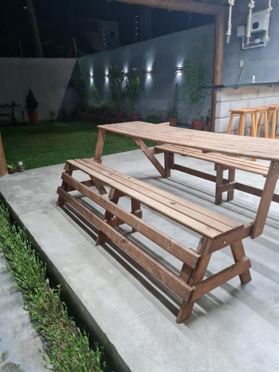 2 mesas de picnic de madera en un patio en Casapraiacururupe en Ilhéus