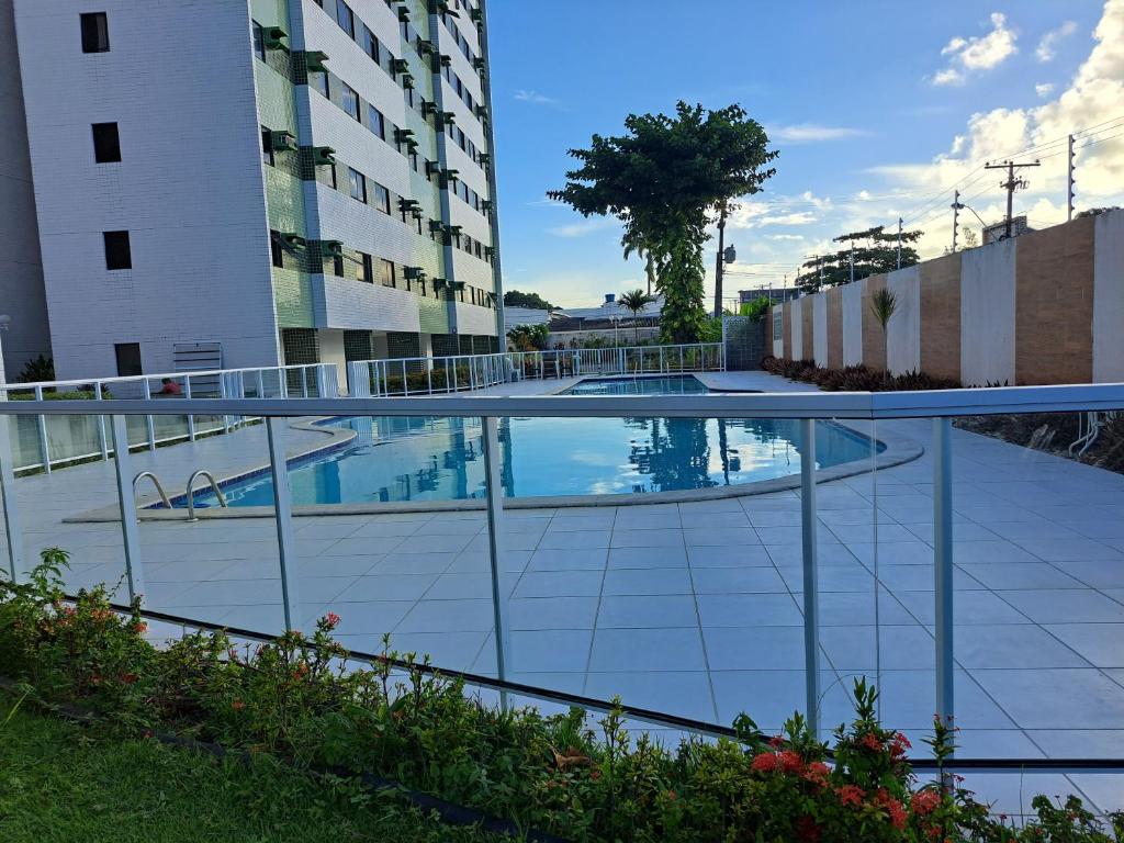 una piscina sul lato di un edificio di Apartamento em Maceió com vista para o mar a Maceió