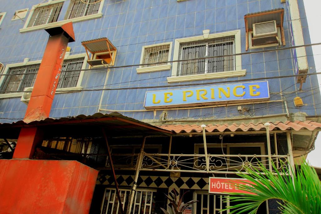 un bâtiment bleu avec un panneau indiquant le prince dans l'établissement Hotel Le Prince, à Cotonou