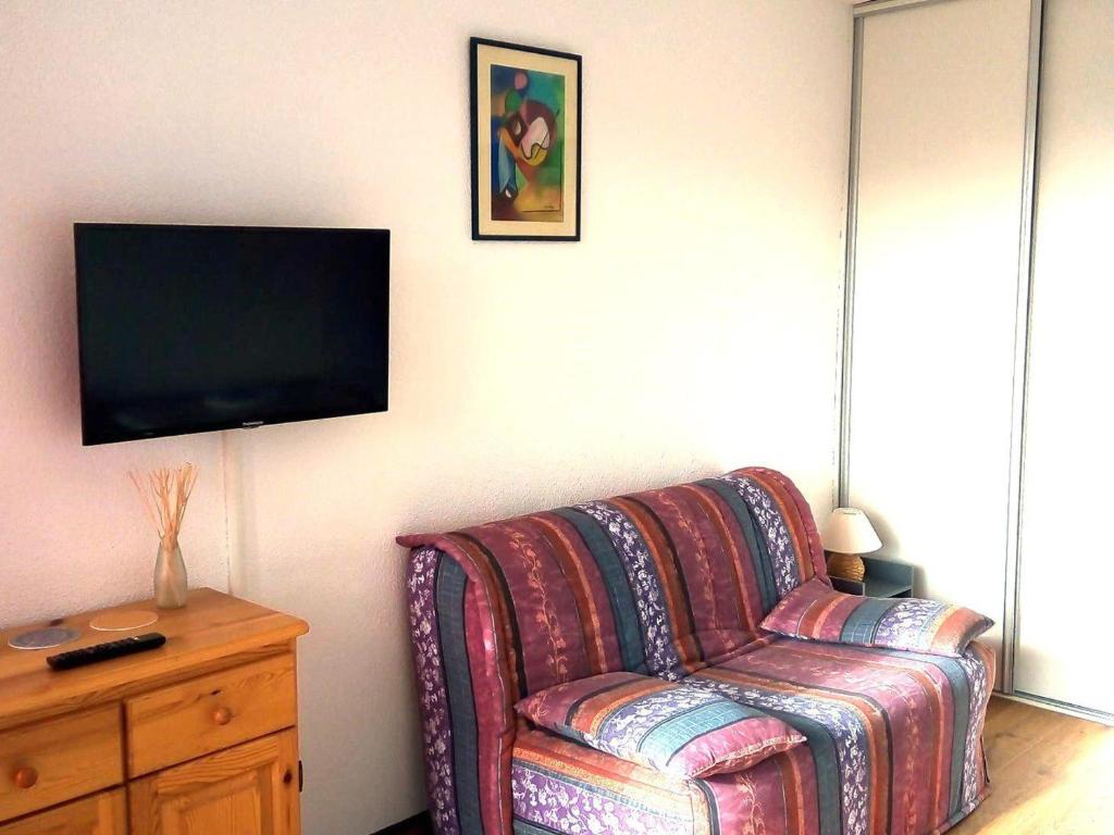 - un salon avec un canapé et une télévision murale dans l'établissement Studio rénové 4 pers au pied des pistes avec équipements complets - FR-1-689-131, à Villard-de-Lans