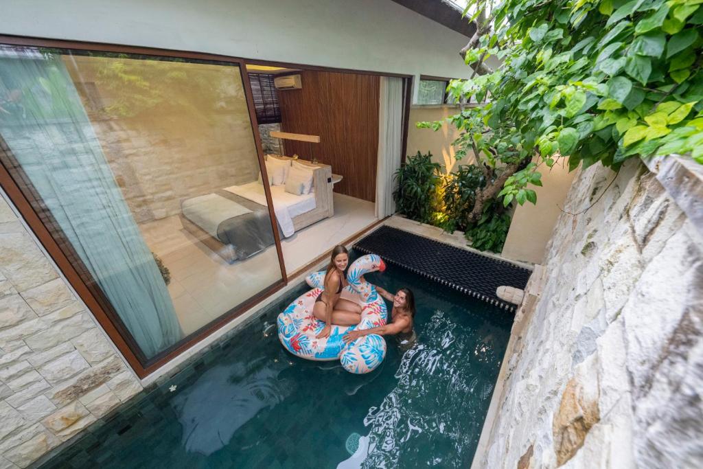 two girls are riding on an inner tube in the water at La Vie Villa Seminyak by Ini Vie Hospitality in Legian