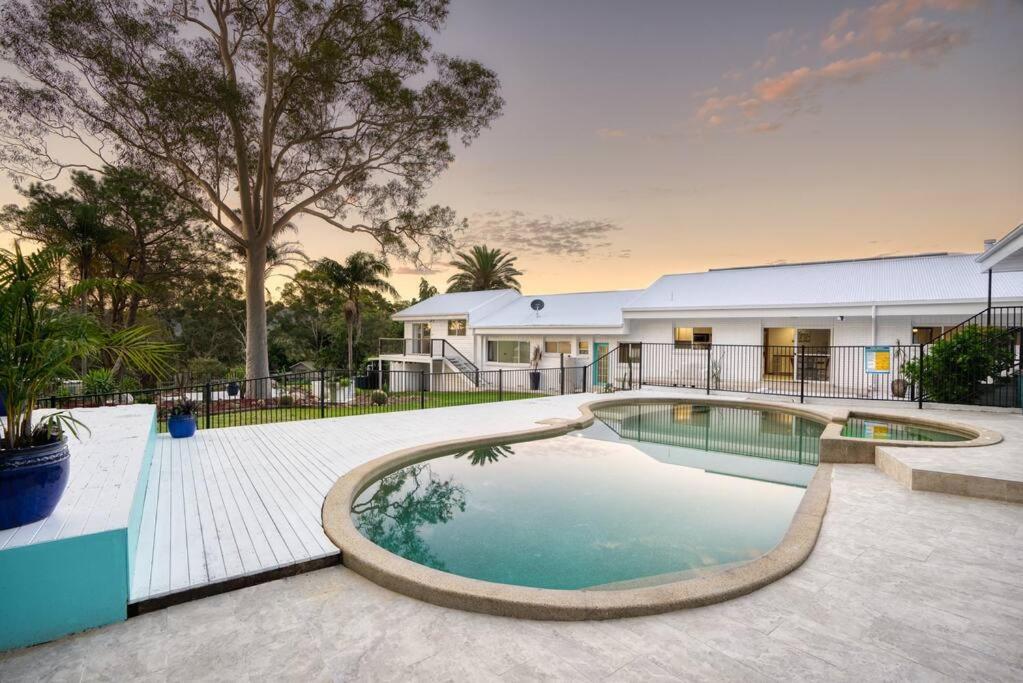 a swimming pool in front of a house at Laguna Niguel - Acreage in Tuggerah