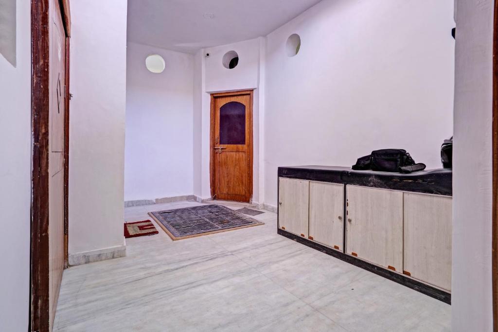 an empty room with a wooden door and a counter at OYO Dream Square in Gwalior