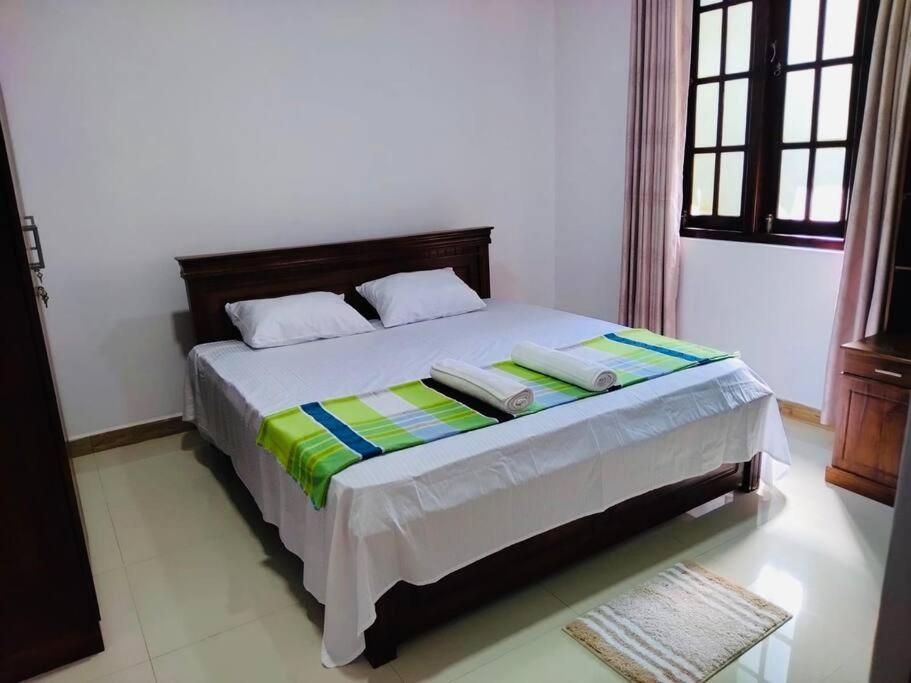een slaapkamer met een bed met 2 kussens erop bij Colombo Villa Near Bolgoda Lake 5 Bed 2.5 Bath in Piliyandala