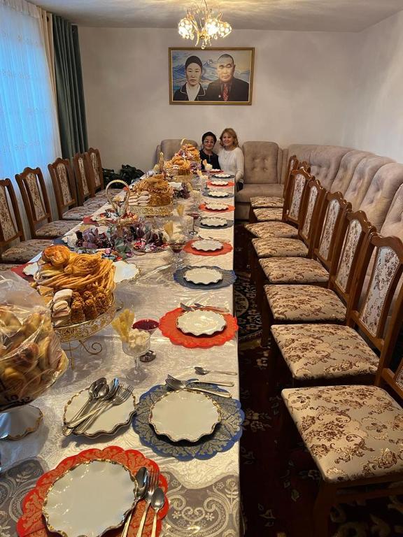 una mesa larga con platos de comida. en Alaaska, en Prigorodnoye