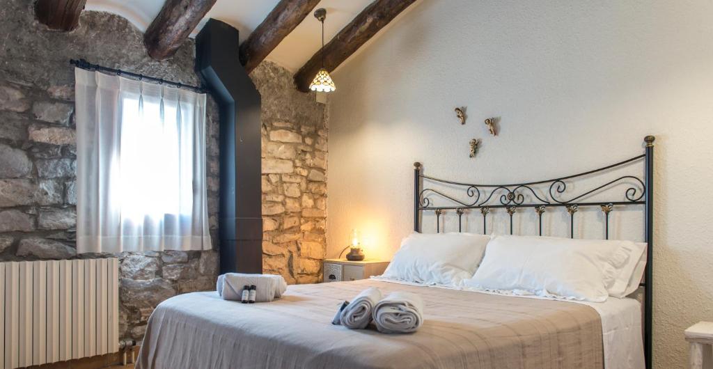 a bedroom with a large bed with towels on it at La Botigueta de Bellmunt in Penellas