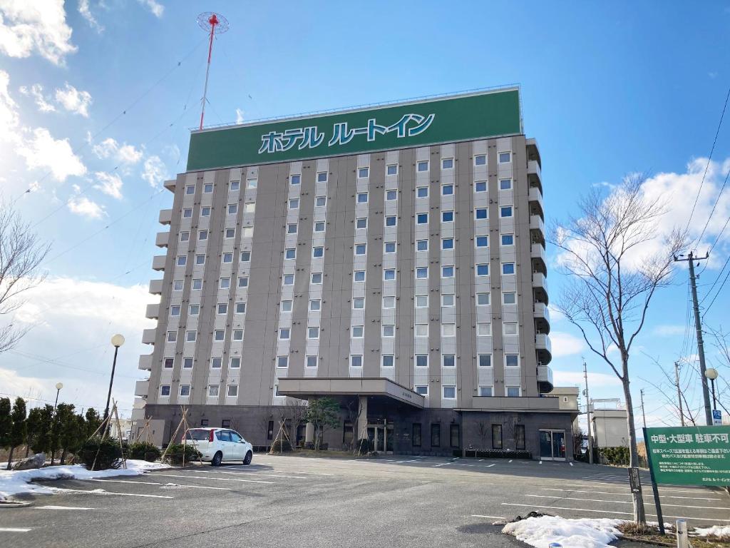 un grande edificio con un cartello sopra di Hotel Route-Inn Aomori Chuo Inter ad Aomori