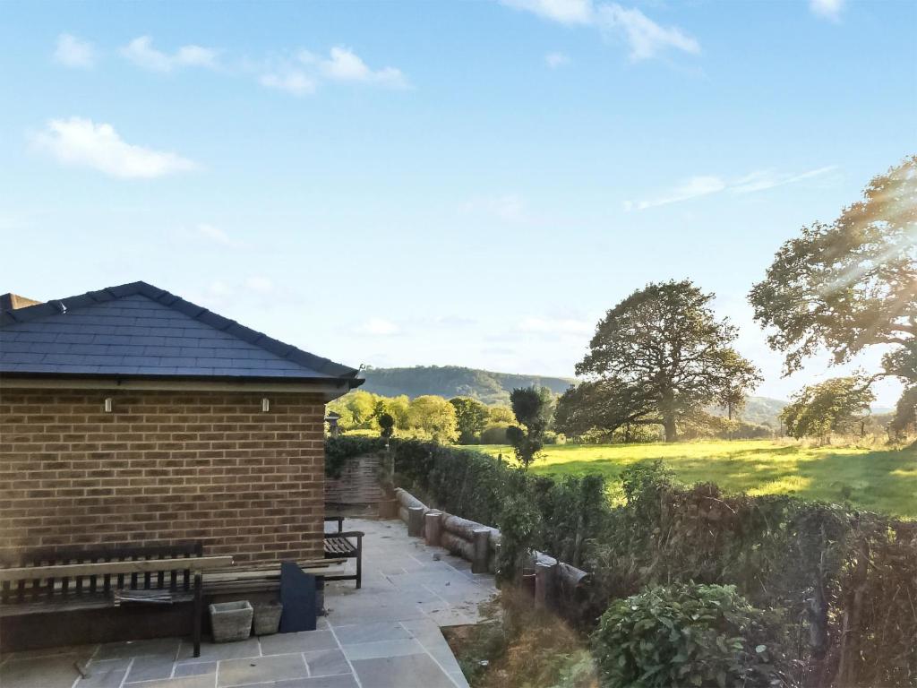 a patio with a bench and a view of a field at Cripps Cottage Annex in Hassocks