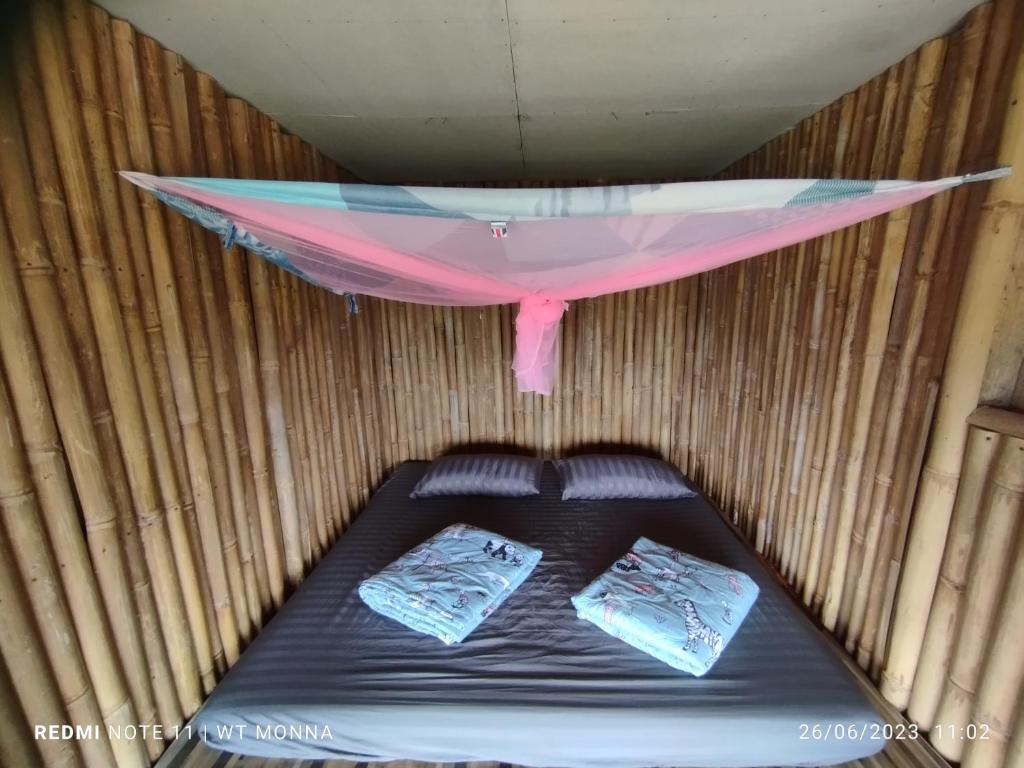 a bed in a room with a tent at ม่อนนาป่าบงเปียง โฮมสเตย์ in Ban Mae Pan Noi