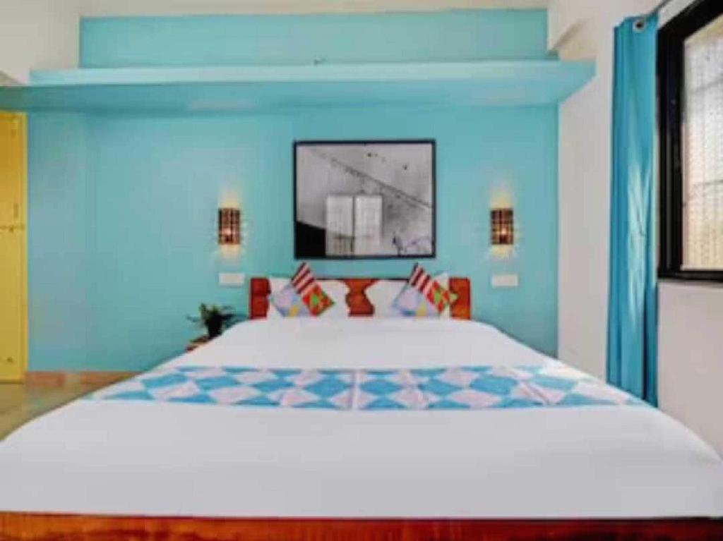 a bedroom with a large bed in a blue room at Flagship Season Inn in Pune