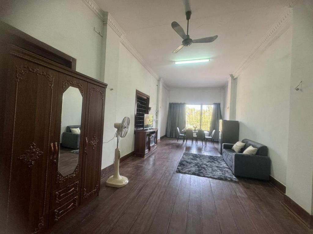 a living room with a couch and a ceiling fan at top loft battambang in Battambang