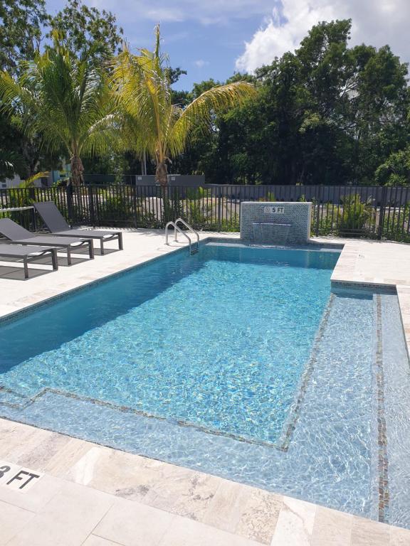una piscina de agua azul en un patio en Modern 1 bedroom walking distance to the beach! en West Bay