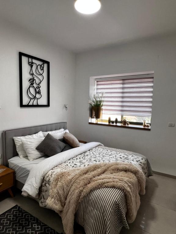 Un dormitorio con una cama grande y una ventana en הפינה של טלי בנהריה - אירוח וספא בריאות מחומם, en Nahariyya