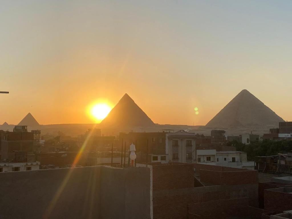 uma vista das pirâmides de Gizé ao pôr-do-sol em horus desert hotel no Cairo