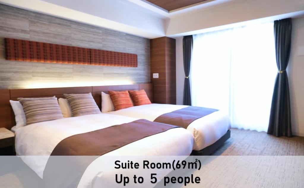 a bedroom with two beds and a large window at LUXCARE HOTEL in Osaka