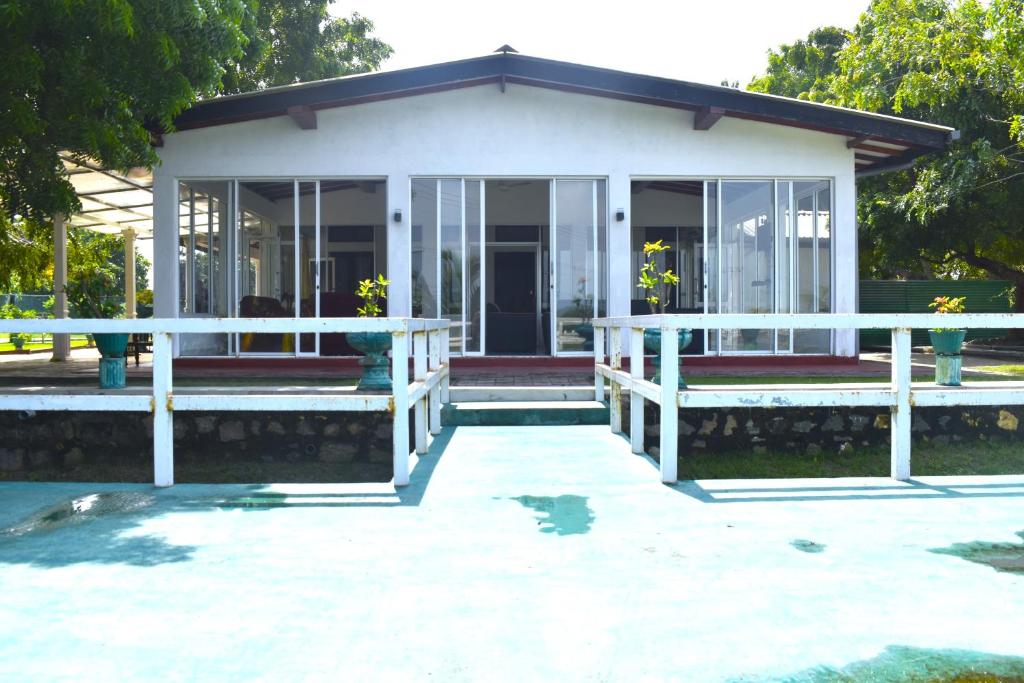 a small white house with glass doors at Thalladi Holiday Bungalow in Mannar