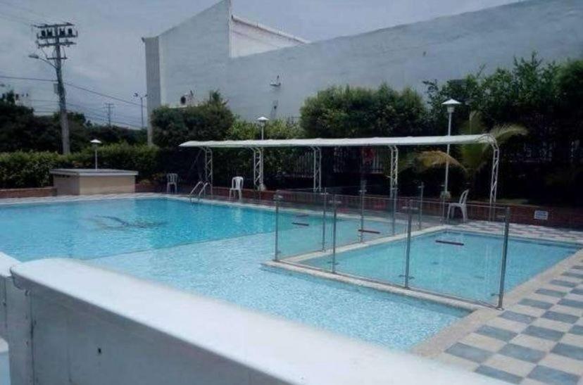 une grande piscine bleue avec un auvent dans l'établissement Habitacion Medusa, à Barranquilla