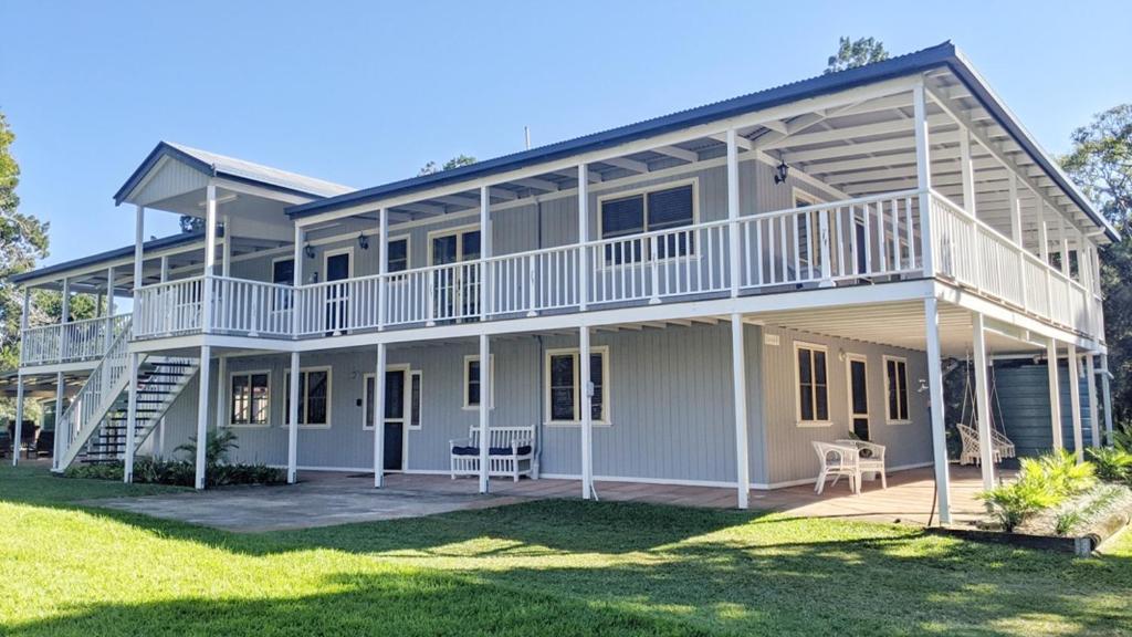 a large white house with a balcony and lawn at Kiarabilli in Bulwer