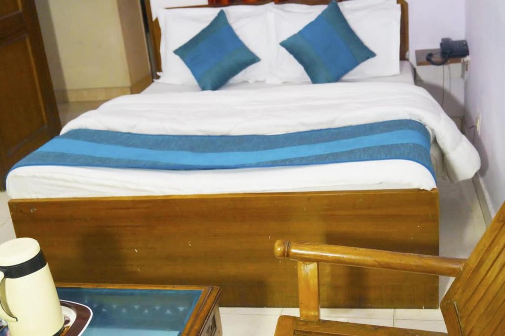 a bed with blue and white pillows in a room at Hotel HRS - New Delhi Railway Station in New Delhi