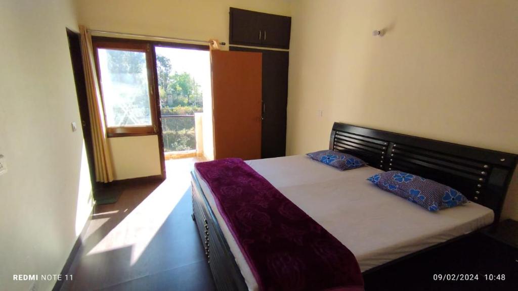 um quarto com uma cama com duas almofadas em Kainchi daam Road Nainital full 2bhk em Nainital