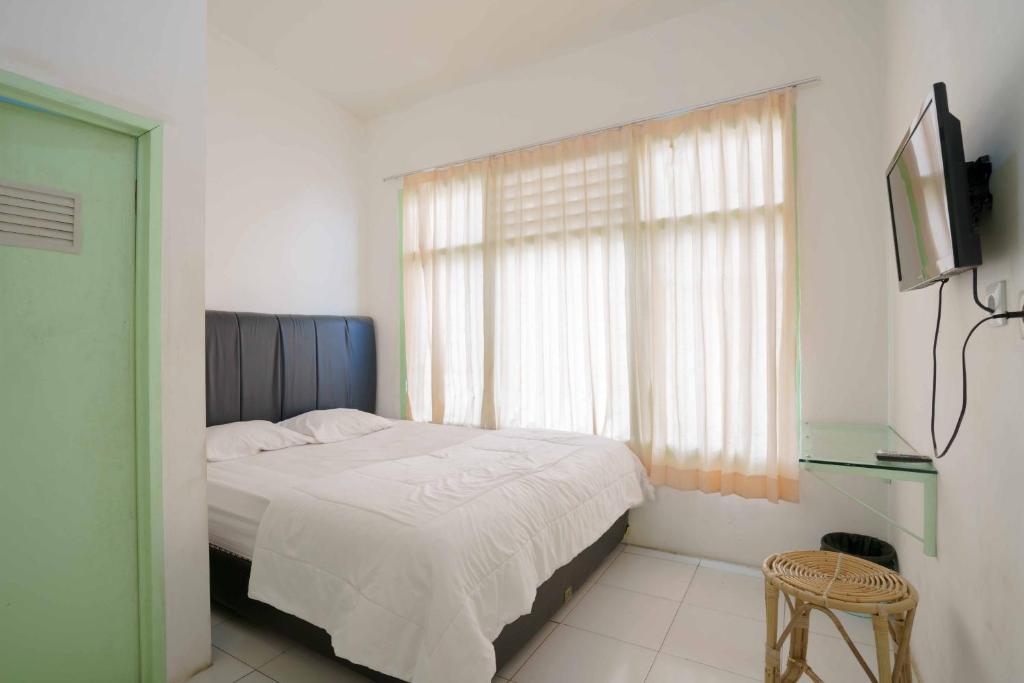 um quarto com uma cama e uma televisão em Lyfriska Residence Lampung RedPartner em Lampung