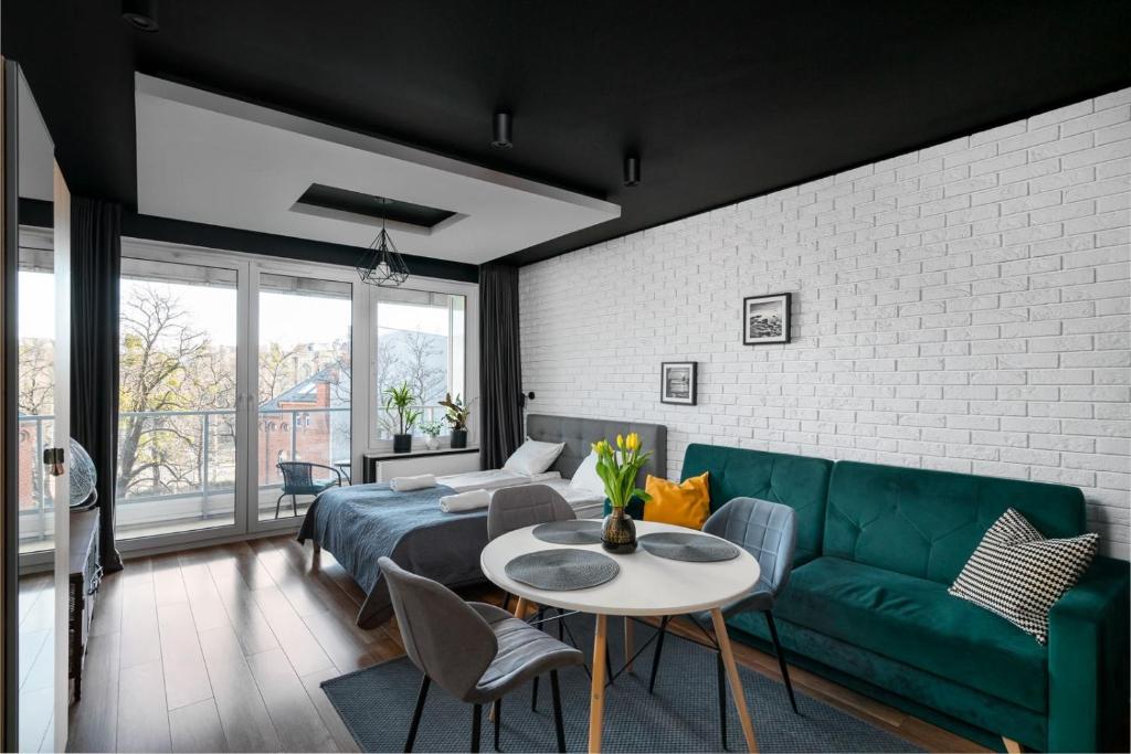 ein Wohnzimmer mit einem grünen Sofa und einem Tisch in der Unterkunft Apartaments 24 Premium Green in Breslau