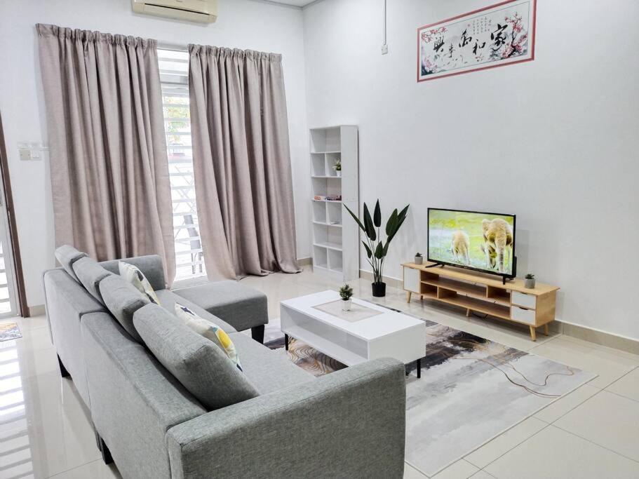 a living room with a couch and a tv at 1793 Kepayang S2 # U Homestay in Seremban