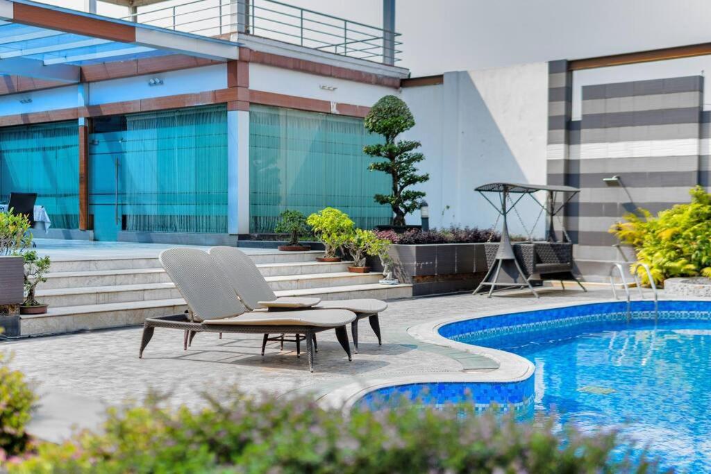 a chair and a table next to a swimming pool at Grand Villa Oasis in Dhaka