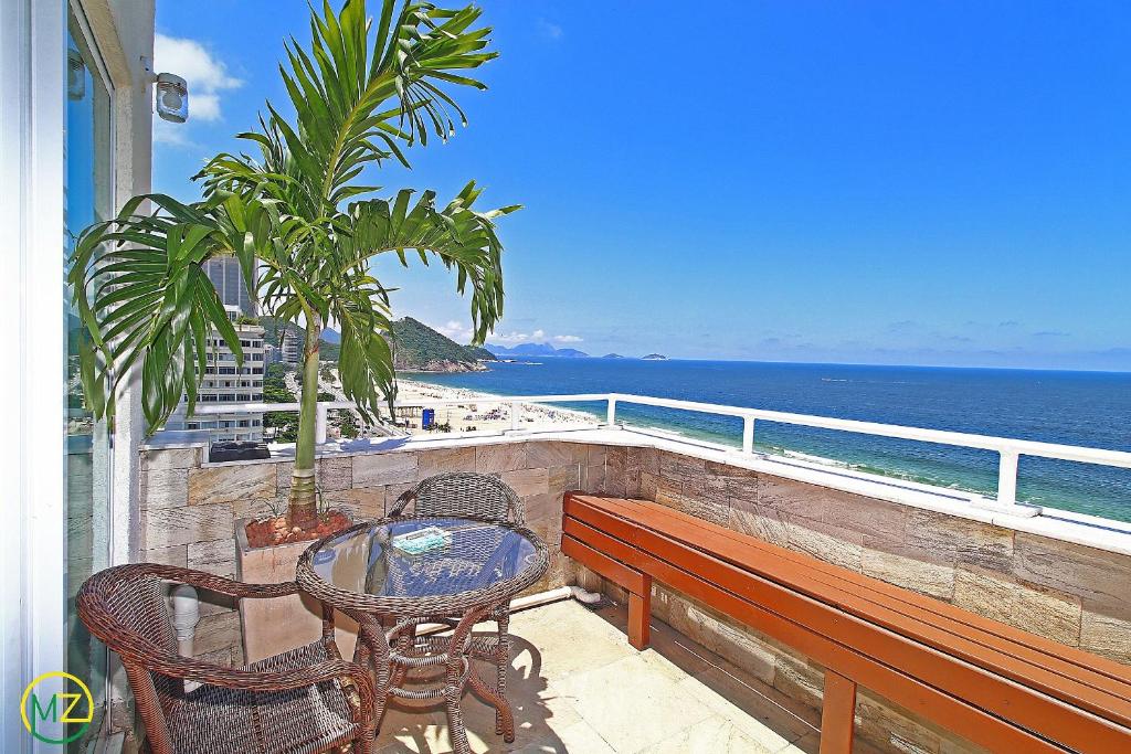 balcón con mesa, sillas y vistas al océano en Incrivel cobertura frente mar com terraço, en Río de Janeiro