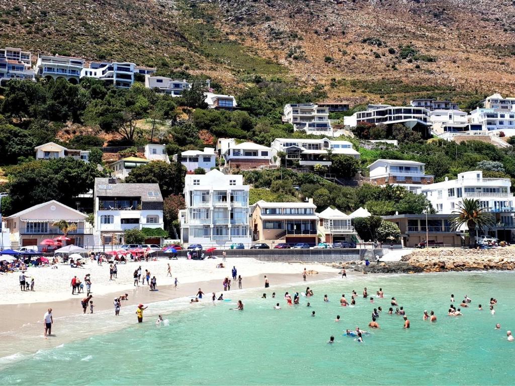a group of people on a beach in the water at The View on Bikini Beach, Sleeps 4 in Gordonʼs Bay