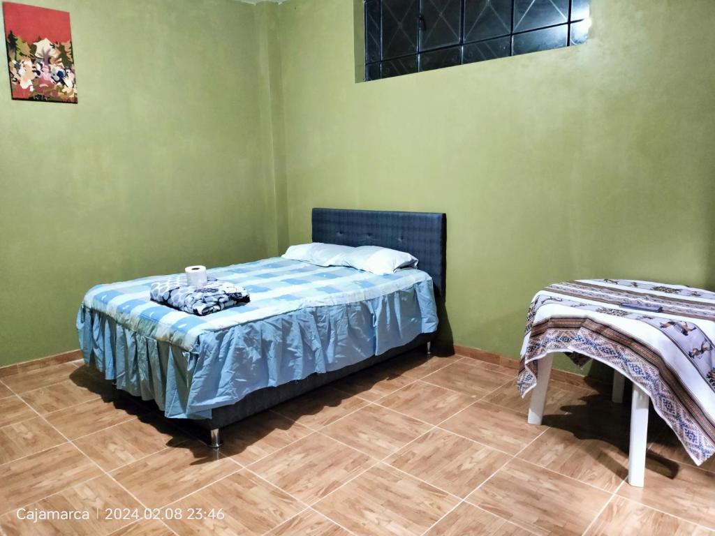 a bedroom with a bed with a blue comforter at Habitación en casa de campo in Cajamarca
