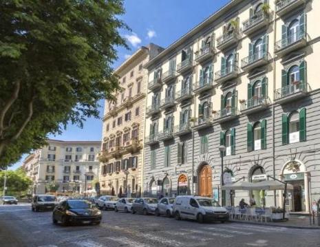 un grand bâtiment avec des voitures garées devant lui dans l'établissement MILUAR Relais - B&B - Vanvitelli, à Naples