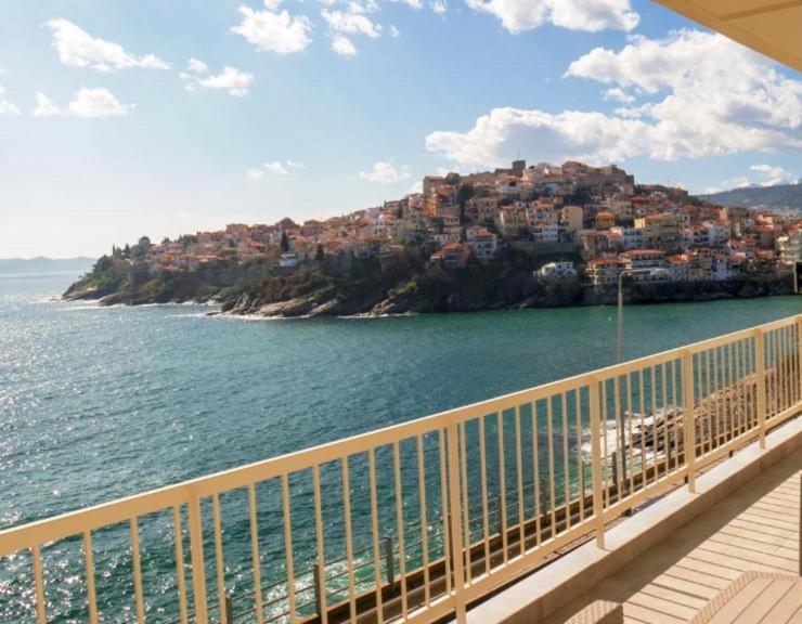 a view of a town on a hill next to the water at Olive House Apartments in Kavála