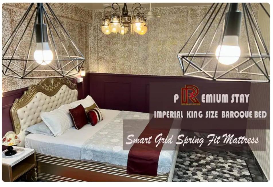 a bedroom with a bed and a chandelier at The Atlantis Guwahati in Guwahati