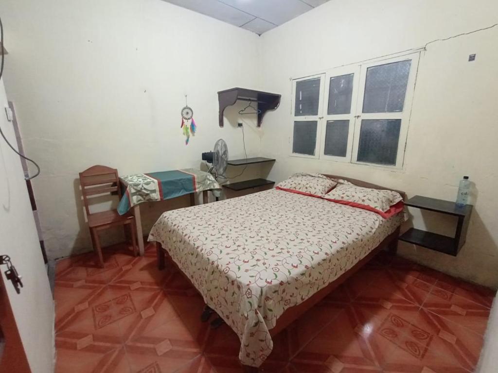 a bedroom with a bed and a desk and a telephone at La 5ta in Iquitos