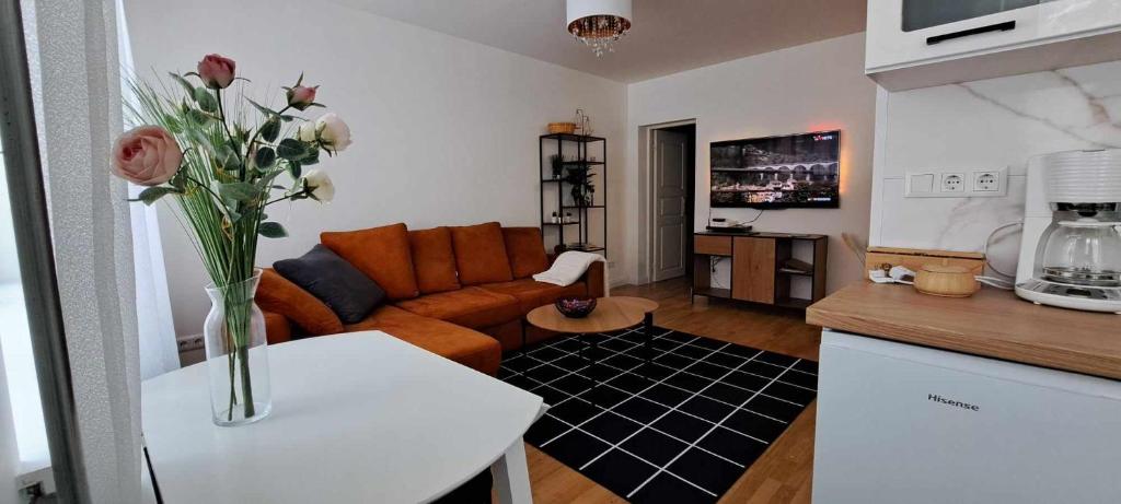a living room with a couch and a vase of flowers on a table at J. Kuperjanov Apartment in Tartu