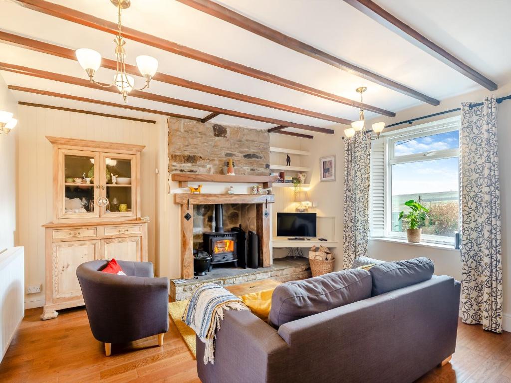 a living room with a couch and a fireplace at Little Gidding in Frosterley