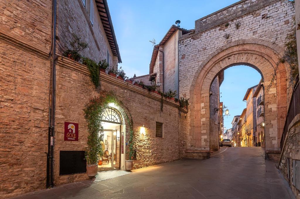 een steegje in een oud gebouw met een boog bij Hotel Sole in Assisi