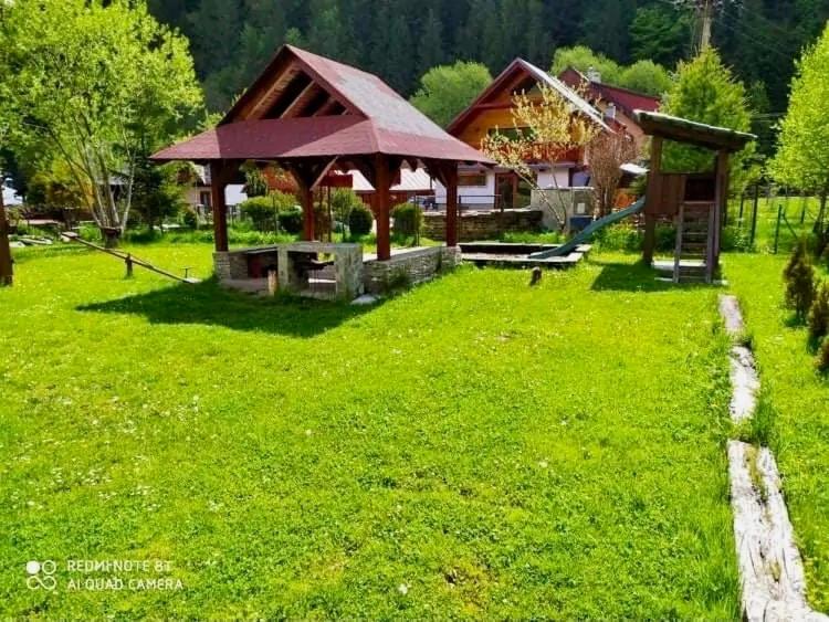 una casa con un cenador en un campo verde en Zázrivský dvor, en Zázrivá