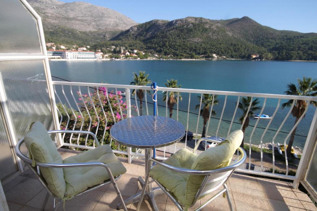 a balcony with a table and chairs and a view of the water at Apartments by the sea Slano, Dubrovnik - 8538 in Slano