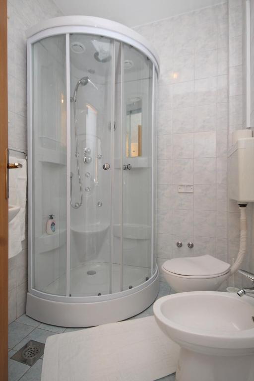 a white bathroom with a shower and a toilet at Apartments by the sea Slano, Dubrovnik - 8538 in Slano