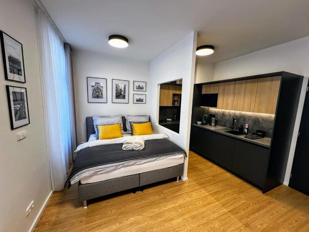 ein kleines Schlafzimmer mit einem Bett und einer Küche in der Unterkunft Home Heart of the center of Brno - Koliště Passage in Brünn