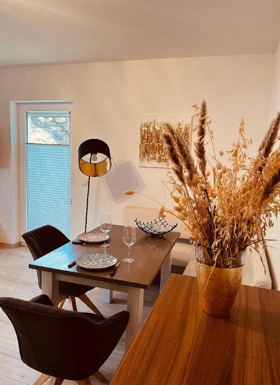 a dining room with a table and chairs and a plant at Ferienwohnung Elfi in Kirchdorf im Wald