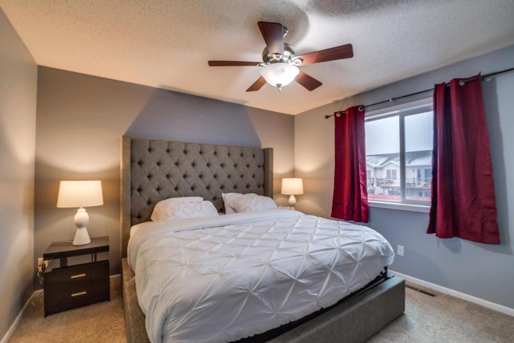 - une chambre avec un lit et un ventilateur de plafond dans l'établissement Charming Retreat With Modern Comforts, à West Fargo